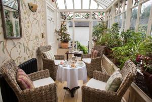 a patio with a table and chairs in a conservatory at Raheen House Hotel in Clonmel