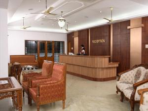 a hotel lobby with a reception desk and chairs at Saaral Resort By Crossway in Kuttālam