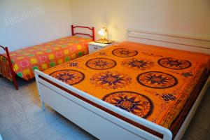 リド・マリーニにあるCasa Vacanza BERMUDAのベッドルーム1室(大型ベッド1台、オレンジの毛布付)