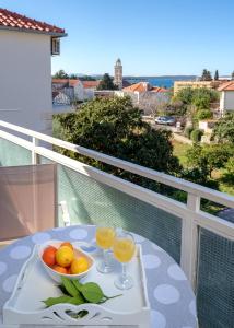 stół z miską owoców i dwa kieliszki soku pomarańczowego w obiekcie Apartments Margita w Hvarze