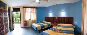 a bedroom with two beds and blue walls at Hotel Villas Kin Ha in Palenque