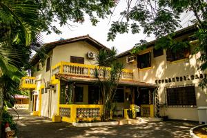 a yellow and white building with a balcony at Beira Mar in Ubatuba