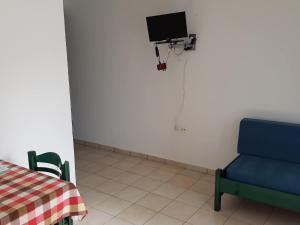 a room with a table and a chair and a tv at Mikes Apartment in Georgioupolis