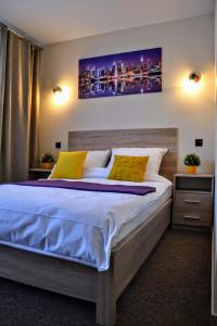 a bedroom with a large bed with two yellow pillows at Mocca House in Raszyn