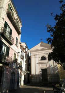 a white building next to two tall buildings at Il sorriso in Salerno