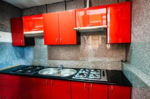 a kitchen with red cabinets and a sink at Pokoje z Widokiem na Morze III in Karwieńskie Błoto Pierwsze