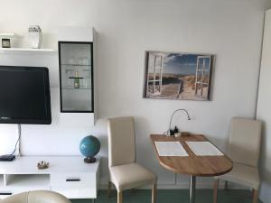 シャルボイツにあるApartment Sonneのテーブル、椅子、テレビが備わる客室です。