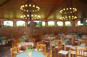 a dining room with tables and chairs and chandeliers at Apartamentos Playa de Los Roques in Los Realejos