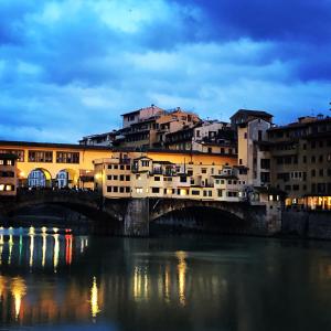 eine Brücke über einen Fluss in einer Stadt mit Gebäuden in der Unterkunft Sweet Apartment in Florence. in Florenz