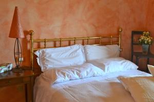 a bed with white sheets and a lamp on a table at Monte A Pescia in Pescia