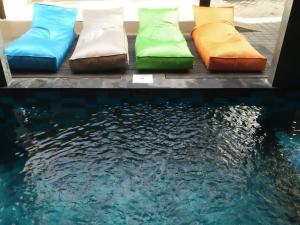 a row of pillows sitting next to a pool of water at Made House Homestay and Dormitory in Sanur