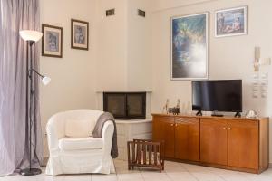 salon z krzesłem i telewizorem w obiekcie Villa Santa Barbara w mieście Maraton