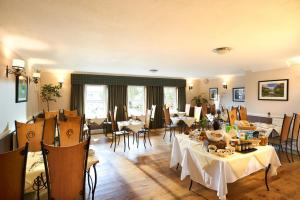 a restaurant with tables and chairs in a room at Poppies Hotel in Callander