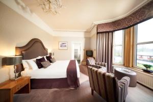 Cette chambre d'hôtel dispose d'un grand lit et de fenêtres. dans l'établissement Poppies Hotel, à Callander