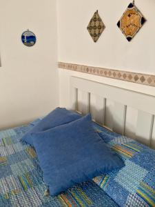 een bed met blauwe kussens erop bij Monolocale Santuzza in Mondello