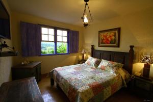 um quarto com uma cama e uma janela em A Casa Vermelha Hospedaria em Tiradentes