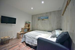 um quarto com uma cama e uma televisão de ecrã plano em Studio "Le Duffit" - RDC em Berck
