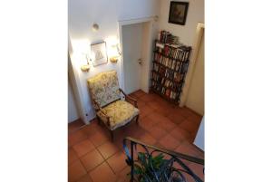 uma sala de estar com uma cadeira e uma estante de livros em Pension Charlotte em Bad Gastein