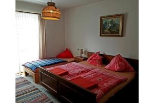 sypialnia z dwoma łóżkami z czerwonymi poduszkami w obiekcie Pension Charlotte w mieście Bad Gastein
