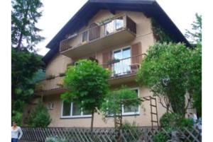 budynek z balkonem i drzewem przed nim w obiekcie Pension Charlotte w mieście Bad Gastein