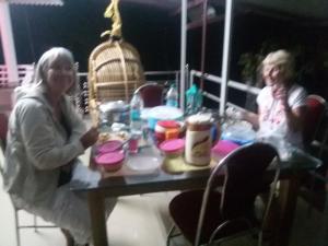 zwei Frauen sitzen an einem Tisch mit Tellern in der Unterkunft Mount Spring Valley Homestay in Thekkady + 29 Fotos