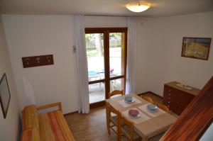 een eetkamer met een tafel en stoelen en een raam bij Ville Carla e Caterina in Bibione