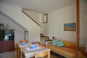 un soggiorno con un tavolo e un divano di Ville Carla e Caterina a Bibione