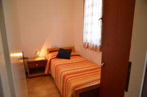 een kleine slaapkamer met een bed en een raam bij Ville Carla e Caterina in Bibione