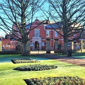 a large red brick building with trees in the yard at Kings Park Hotel in Retford