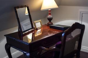 a desk with a mirror and a lamp on it at The Old Vine in Winchester