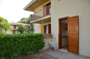 un WC esterno a un edificio con balcone di Ville Carla e Caterina a Bibione