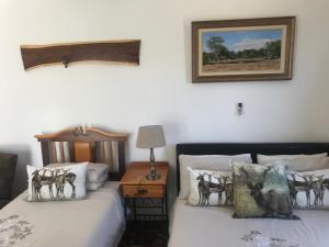 1 dormitorio con 2 camas y una foto en la pared en Towerzicht Guest House, en Ladismith
