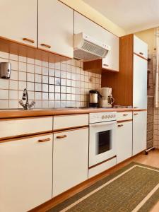 a kitchen with white cabinets and a stove at Haus Alpenrose in Trins