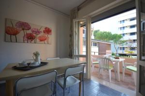 a dining room with a table and chairs and a balcony at Appartamenti Villa Angela in Bibione