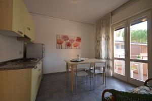 a small kitchen with a table and chairs and a window at Appartamenti Villa Angela in Bibione