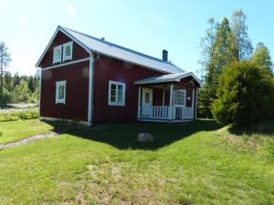 a red house on a field with a grass yard at Ferienhaus Brittsbo in Ramvik