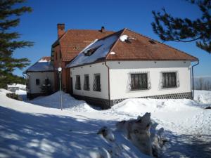 a white house with a red roof in the snow at Hotel Villa Dorata in Nicolosi