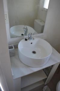 ein weißes Badezimmer mit Waschbecken und Spiegel in der Unterkunft Villa Bono in Santa Clara del Mar + 14 Fotos