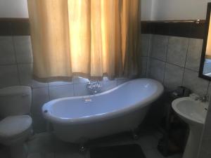 y baño con bañera, aseo y lavamanos. en Towerzicht Guest House, en Ladismith