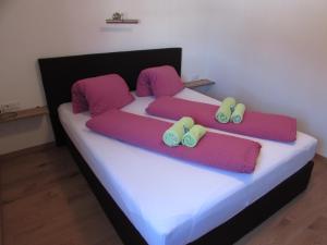 GrinsにあるApart Schranzのベッドルーム1室(紫とピンクの枕が備わるベッド2台付)