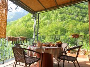 una mesa y sillas en un balcón con vistas en B&B Rossociliegia en Castelbianco