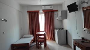 una piccola stanza con un letto e una finestra di Karmi Apartments a Kolymvari