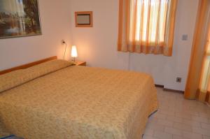 a hotel room with a bed and a window at Villaggio San Siro in Bibione