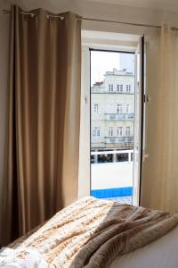 um quarto com uma cama e uma grande janela em Soldouro Guesthouse em Aveiro