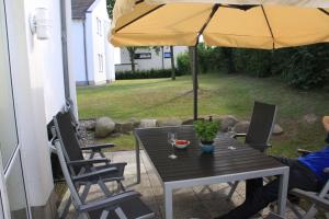ein Tisch und Stühle mit einem Sonnenschirm auf einer Terrasse in der Unterkunft Amselstern Binz in Binz