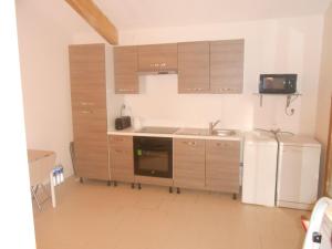 a kitchen with wooden cabinets and a refrigerator at La petite danseuse in Franquevielle
