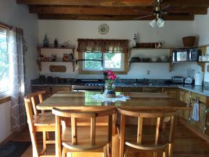 a kitchen with a wooden table and wooden chairs at Jonesville Point beach house in Roatan