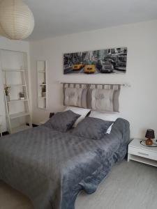 een slaapkamer met een bed en een foto aan de muur bij Villa Face Mer in Audresselles