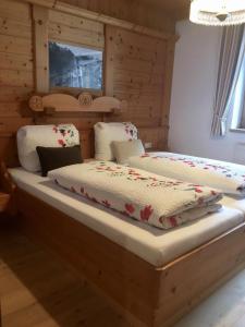 two twin beds in a room with wooden walls at Haus Marco in Neustift im Stubaital