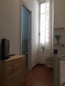 sypialnia z telewizorem na komodzie i oknem w obiekcie Hotel Villa Cristina w Rapallo